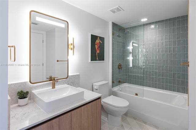 full bathroom featuring tiled shower / bath, vanity, and toilet