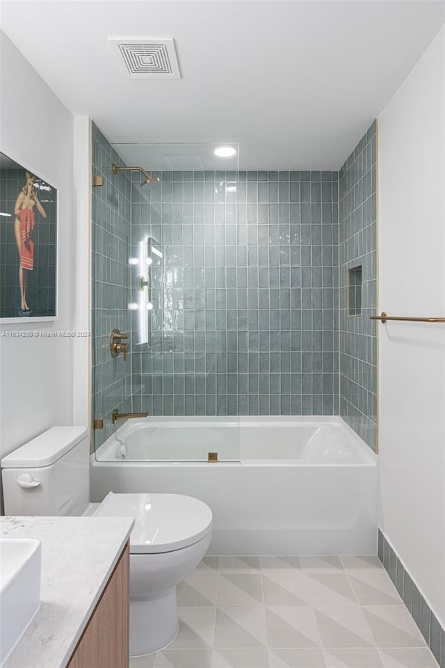 full bathroom featuring tiled shower / bath, toilet, and vanity