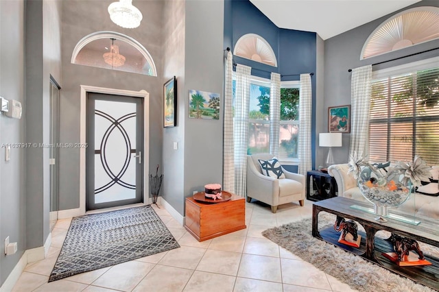 tiled entryway featuring a towering ceiling and an inviting chandelier