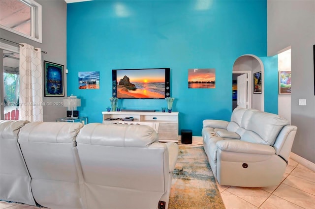 tiled living room featuring a high ceiling