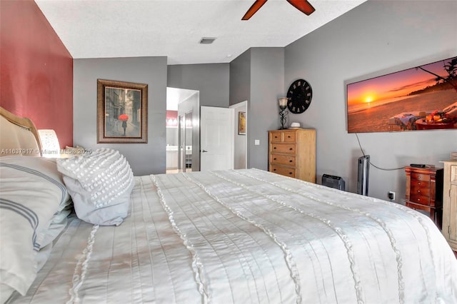 bedroom with a textured ceiling, ceiling fan, ensuite bathroom, and lofted ceiling