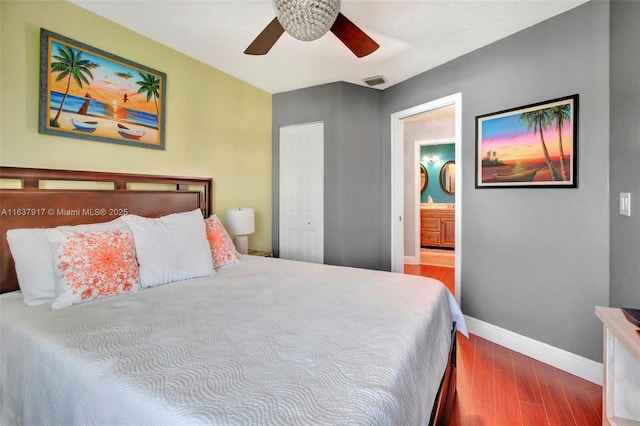 bedroom featuring hardwood / wood-style flooring, ceiling fan, ensuite bathroom, and a closet