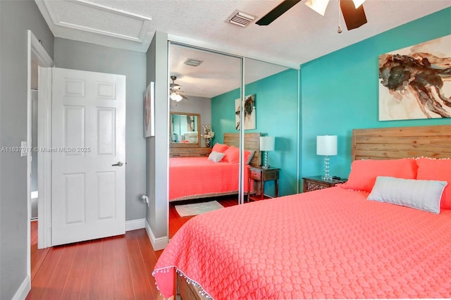 bedroom featuring wood-type flooring, a textured ceiling, a closet, and ceiling fan