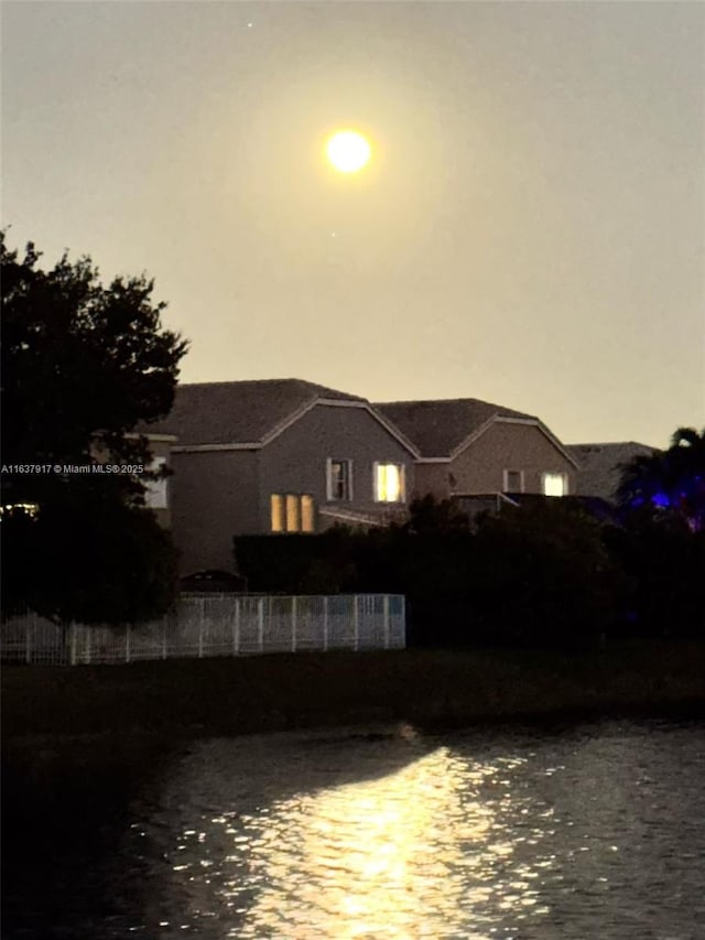 back house at dusk featuring a water view