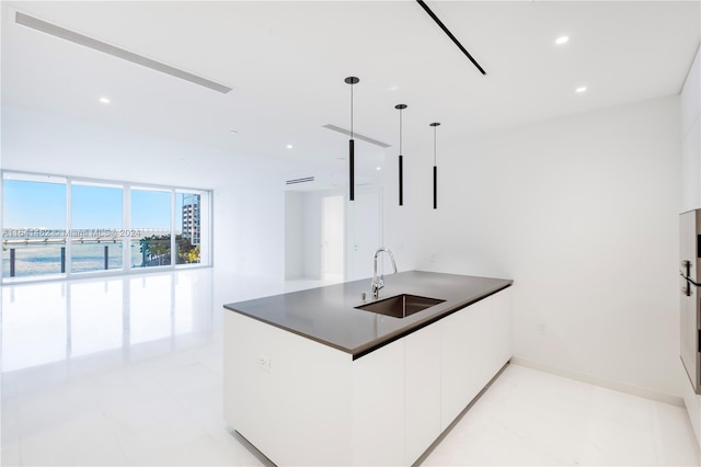 kitchen with sink, white cabinets, and pendant lighting