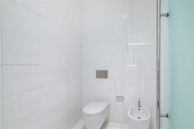 bathroom with toilet, tile walls, a bidet, and an enclosed shower