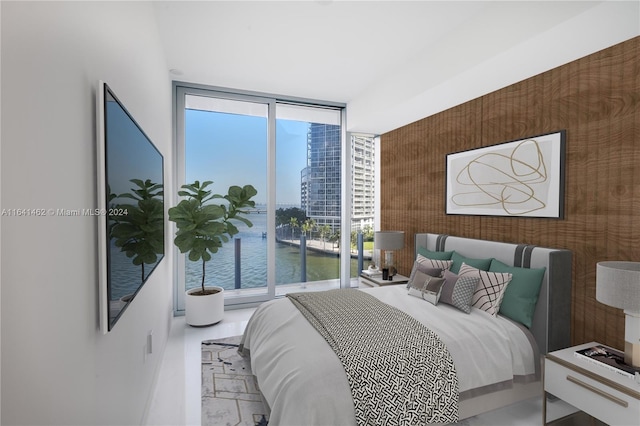 bedroom featuring a water view, multiple windows, and a wall of windows