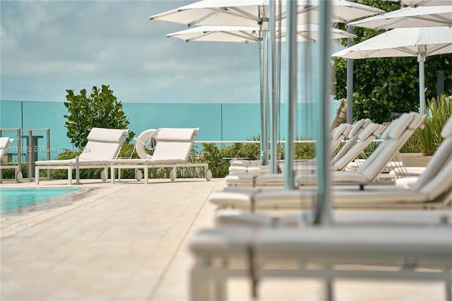 view of swimming pool featuring a patio and a water view