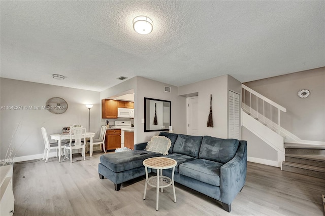 living room featuring a textured ceiling and light wood-type flooring