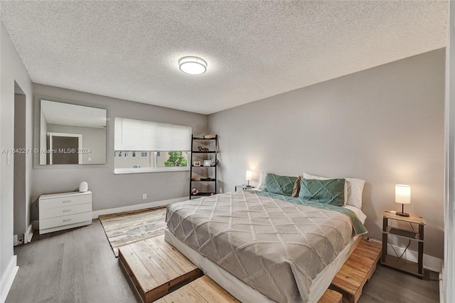 bedroom featuring light hardwood / wood-style flooring and a textured ceiling