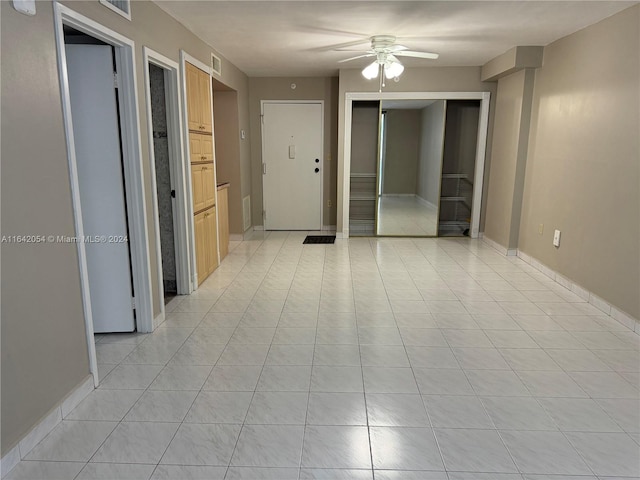 tiled spare room with ceiling fan