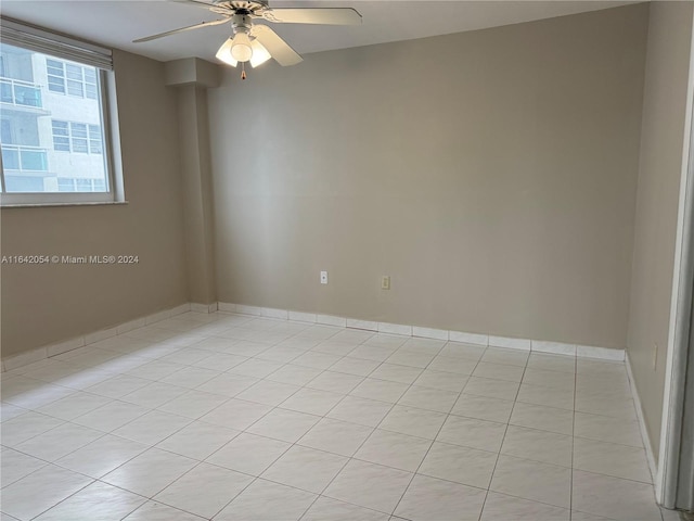 empty room with ceiling fan and light tile patterned floors