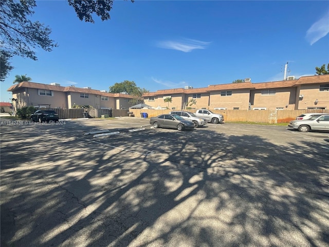 uncovered parking lot with fence and a residential view