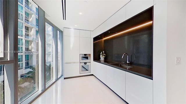 kitchen with sink, white cabinetry, and tasteful backsplash