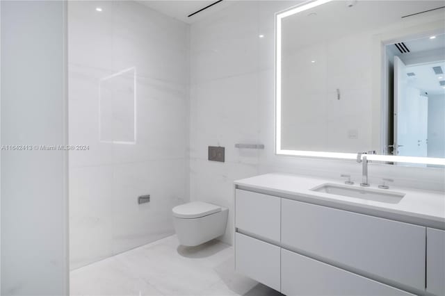 bathroom with vanity, toilet, and tile walls