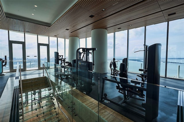 workout area featuring a water view and a wall of windows