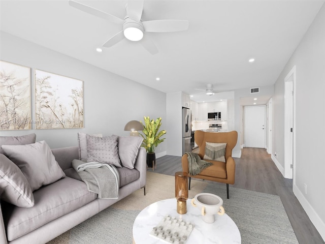 living room featuring hardwood / wood-style floors and ceiling fan