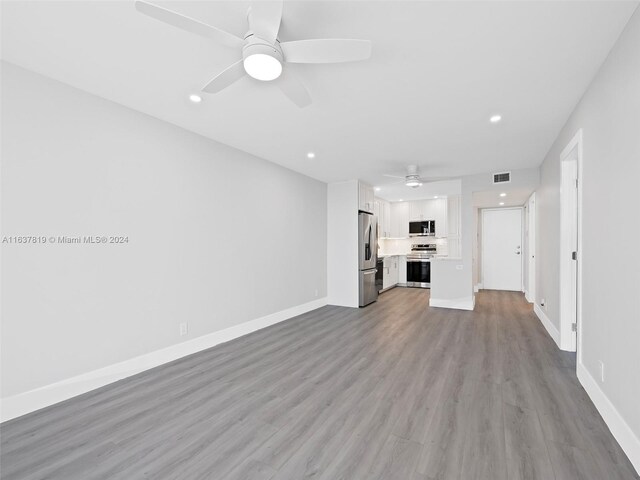 unfurnished living room featuring ceiling fan and light hardwood / wood-style flooring