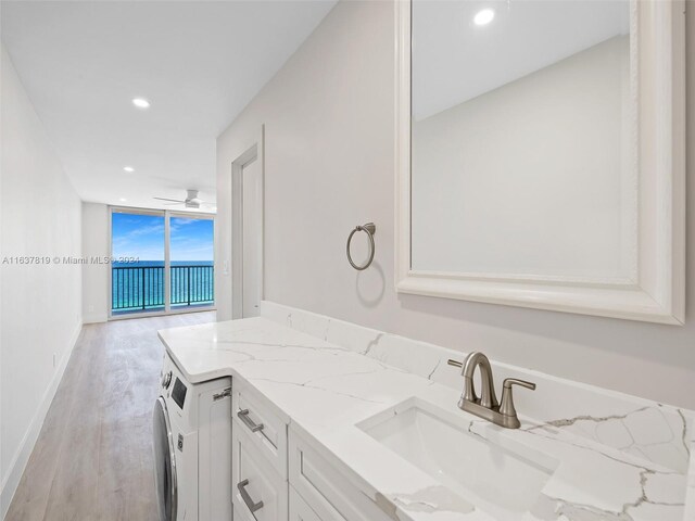 bathroom with ceiling fan, washer / dryer, vanity, and wood-type flooring