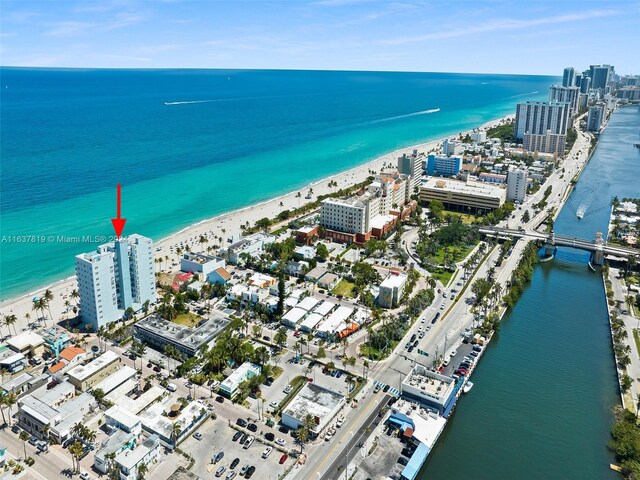 drone / aerial view with a water view and a beach view