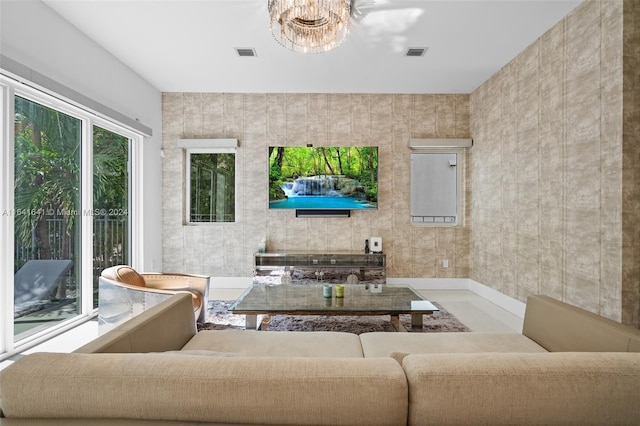 living room featuring a chandelier and tile walls