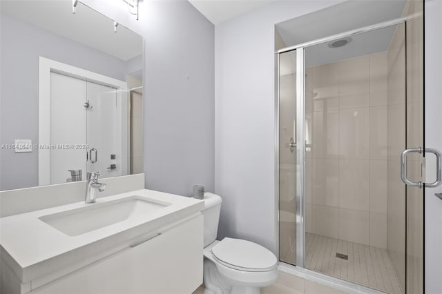 bathroom with a shower with shower door, toilet, and vanity