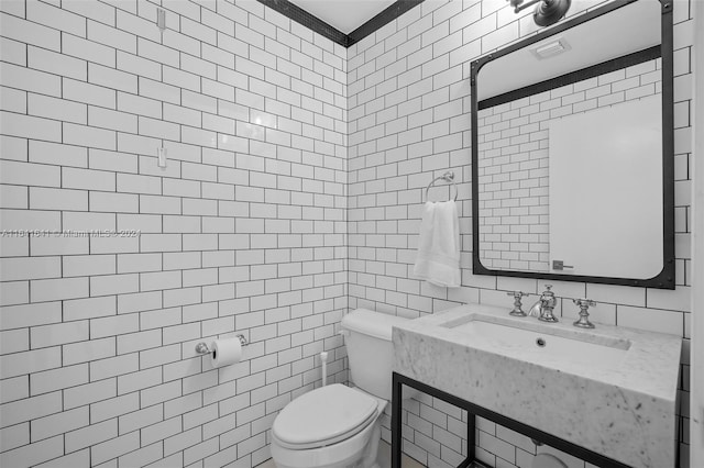 bathroom featuring sink, toilet, and tile walls