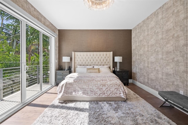 18935 Atlantic Blvd, Sunny Isles Beach, FL 33160 - bedroom featuring access to exterior, a chandelier, wood finished floors, and baseboards