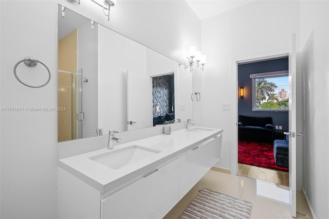 bathroom with tile patterned flooring, dual vanity, and a shower with shower door