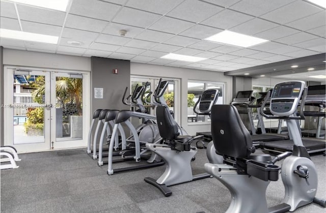 exercise room featuring a paneled ceiling and french doors