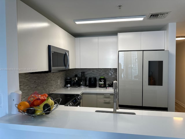 kitchen with visible vents, electric range oven, stainless steel microwave, light countertops, and smart refrigerator