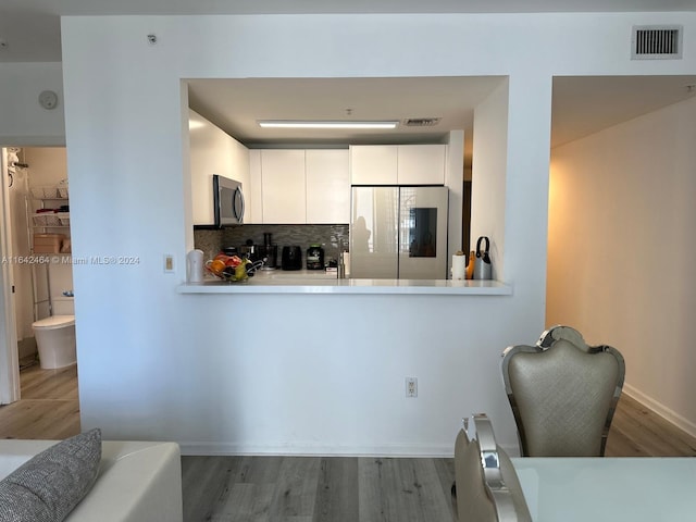 kitchen featuring stainless steel microwave, visible vents, decorative backsplash, smart refrigerator, and wood finished floors