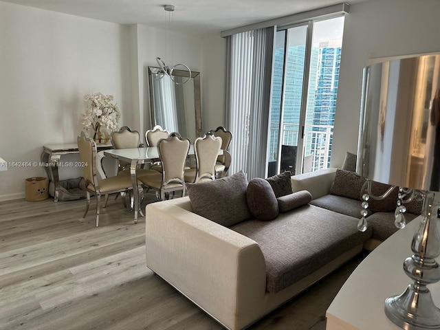 living area featuring a chandelier, a wall of windows, and wood finished floors