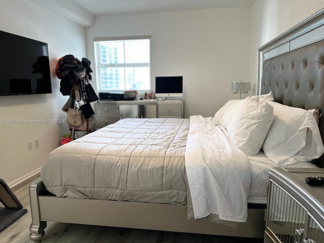 bedroom with wood finished floors and baseboards