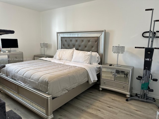 bedroom with baseboards and wood finished floors