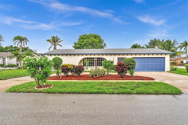 single story home with a front yard and a garage