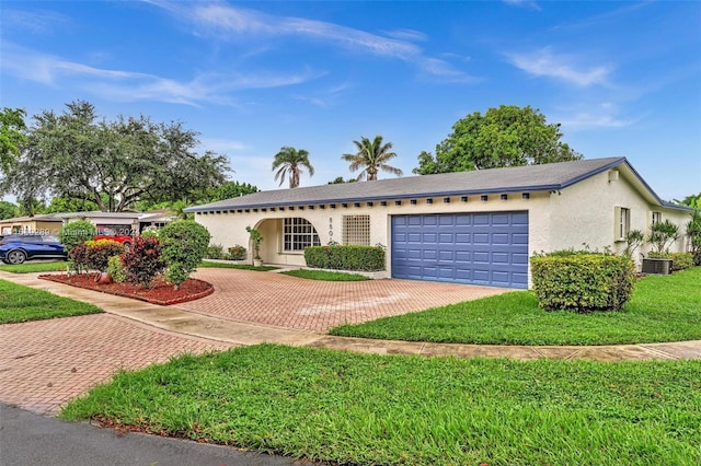 ranch-style house with a garage, central AC unit, and a front yard