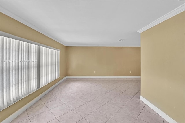 spare room with ornamental molding and light tile patterned floors