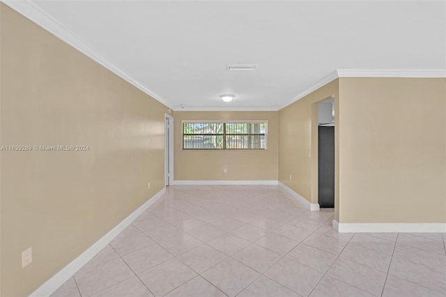 tiled empty room featuring crown molding