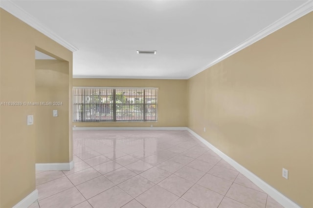 tiled empty room featuring ornamental molding