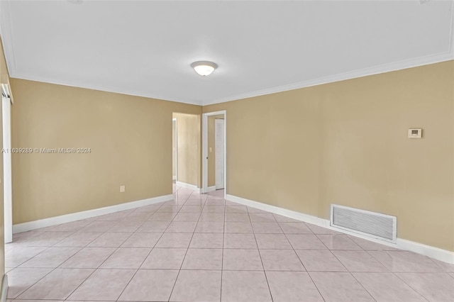 tiled empty room featuring ornamental molding