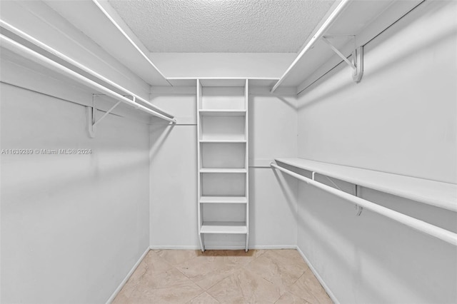 spacious closet with light tile patterned floors