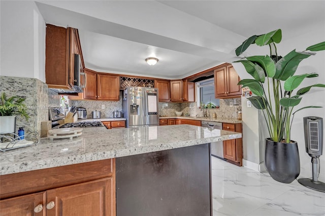 kitchen with light stone counters, sink, kitchen peninsula, backsplash, and stainless steel appliances