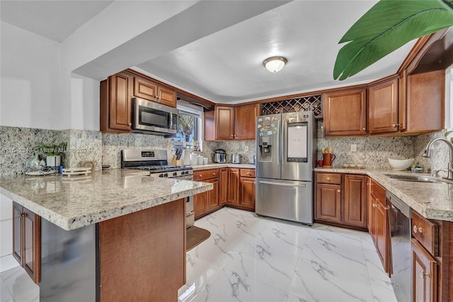 kitchen featuring light stone counters, tasteful backsplash, sink, kitchen peninsula, and appliances with stainless steel finishes