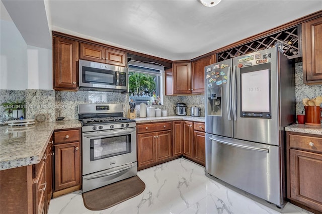 kitchen featuring appliances with stainless steel finishes, decorative backsplash, and light stone countertops