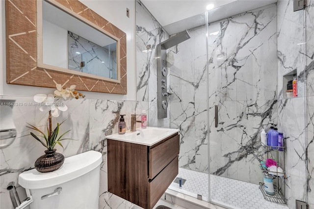 bathroom featuring tile walls, vanity, toilet, and an enclosed shower