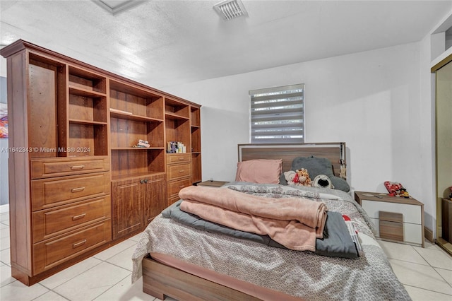 tiled bedroom with a textured ceiling