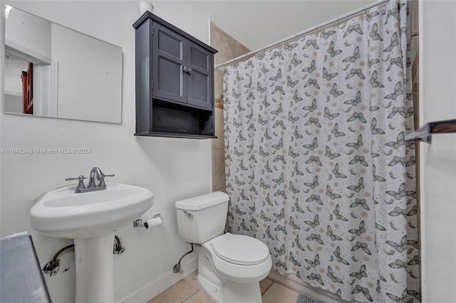 bathroom with a shower with shower curtain, tile patterned flooring, sink, and toilet