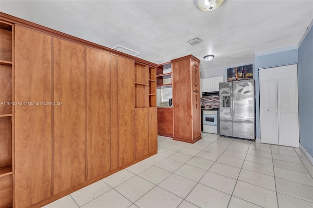 kitchen with white range, light tile patterned floors, and stainless steel fridge with ice dispenser