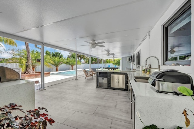 view of patio / terrace with sink, ceiling fan, and exterior kitchen